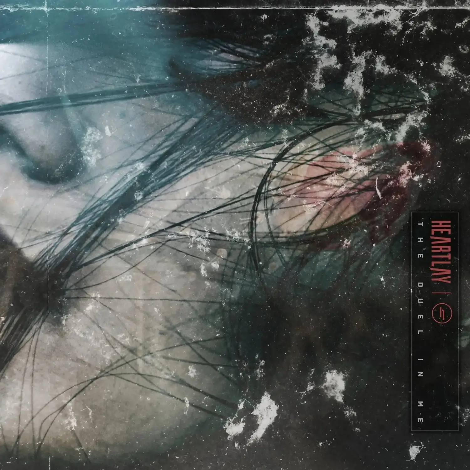 Cover art for Heartlay’s single ‘The Duel In Me’, featuring a fragmented, close-up image of a distressed face partially obscured by strands of black hair and textured visual noise.