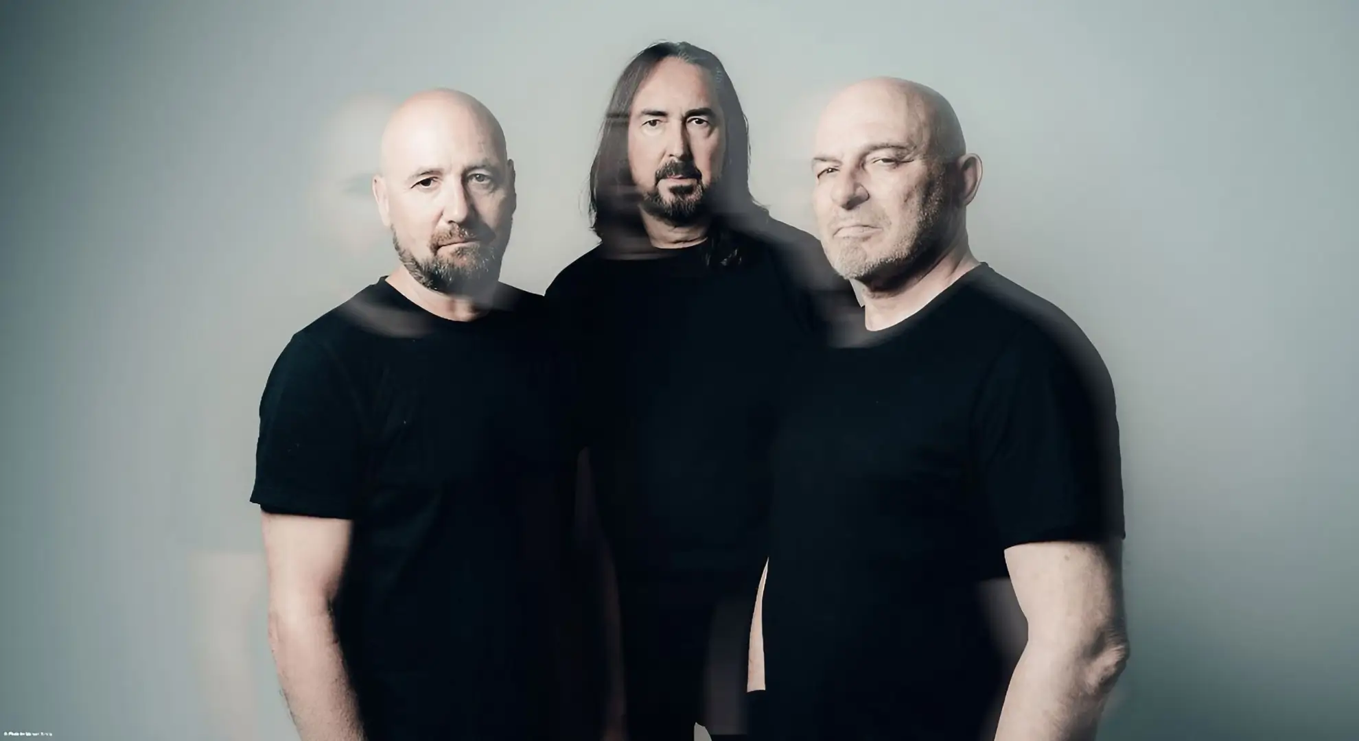 The three members of the Swiss metal band Coroner in a promotional photo with a motion blur effect.
