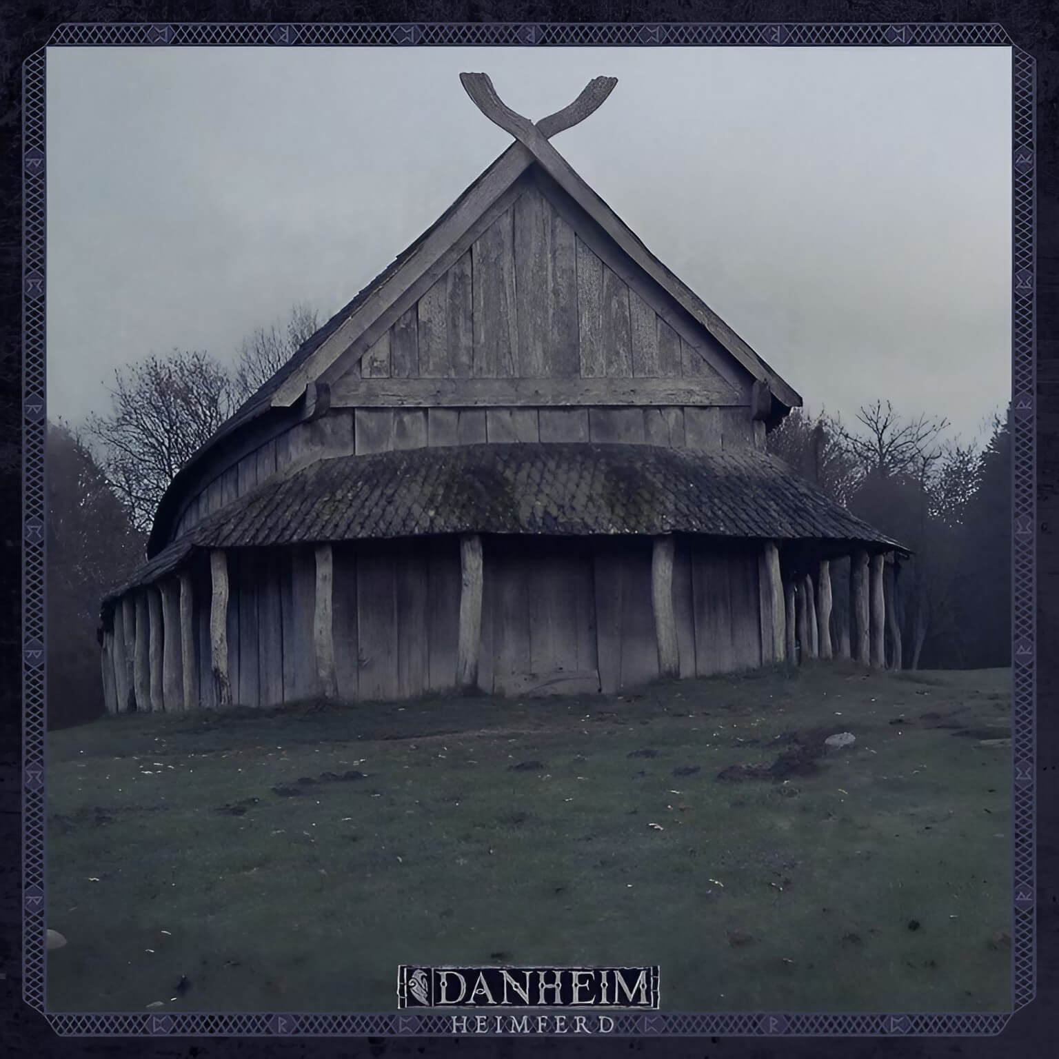 Traditional Nordic wooden longhouse with crossed timber roof beams against overcast sky, framed by decorative border with Danheim’s ‘Heimferd’ text.