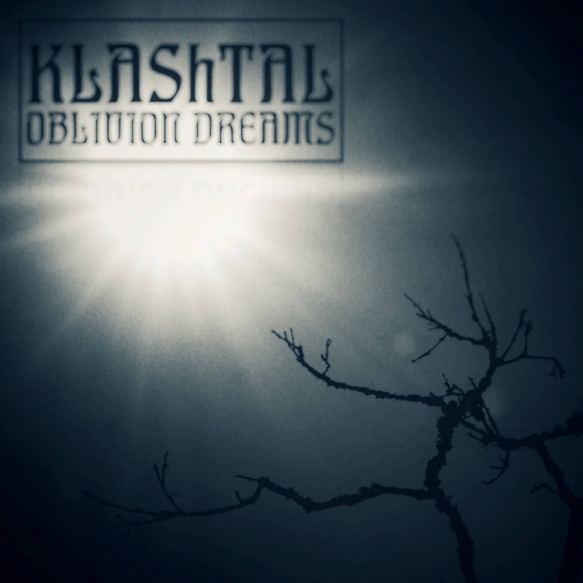 Album artwork for ‘Oblivion Dreams’ by Klashtal. A bright light shines in a dark, hazy sky over the silhouette of a bare tree branch.