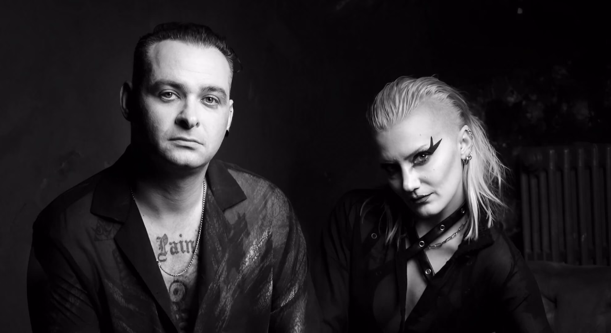 A moody, black-and-white portrait of the two members of Ductape against a dark, textured background.