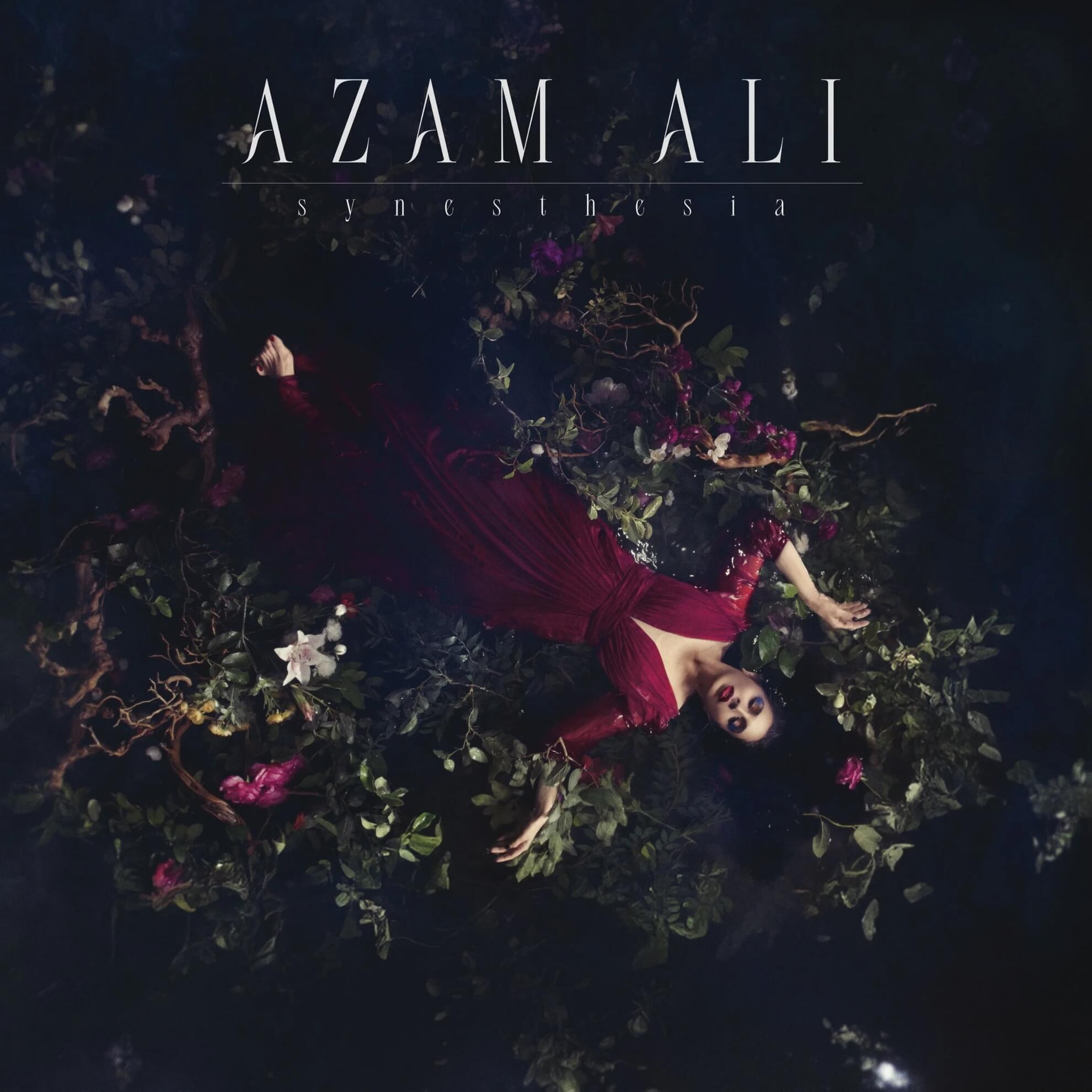Album cover for ‘Synesthesia.’ Azam Ali in a red dress floats in dark water surrounded by flowers and leaves.