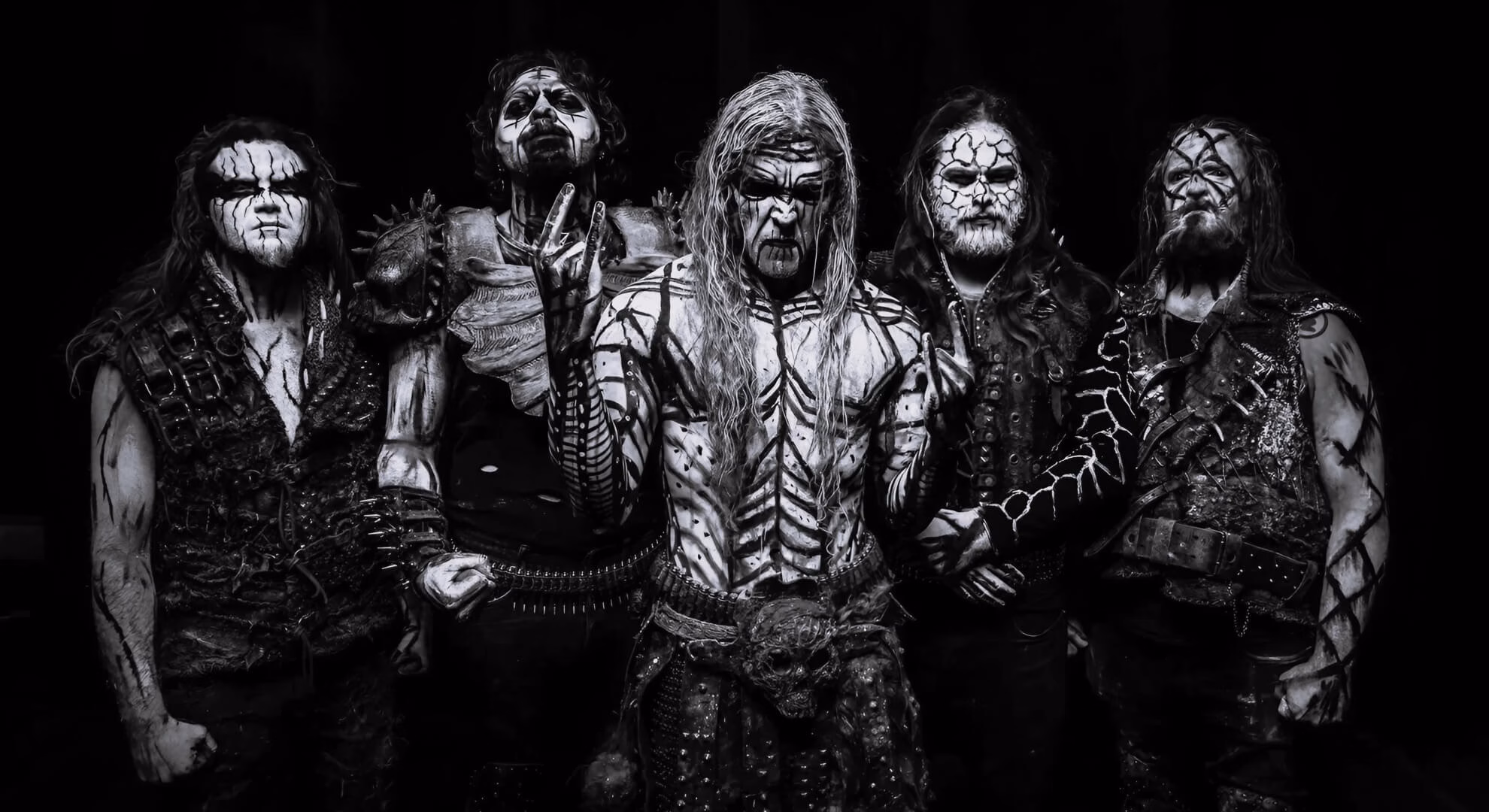 Thy Antichrist Unleashes the Beast on the Southern Cone in 2026 Thy Antichrist band members stand stoically in full ritual body paint and leather armor against a textured, dark gray background.