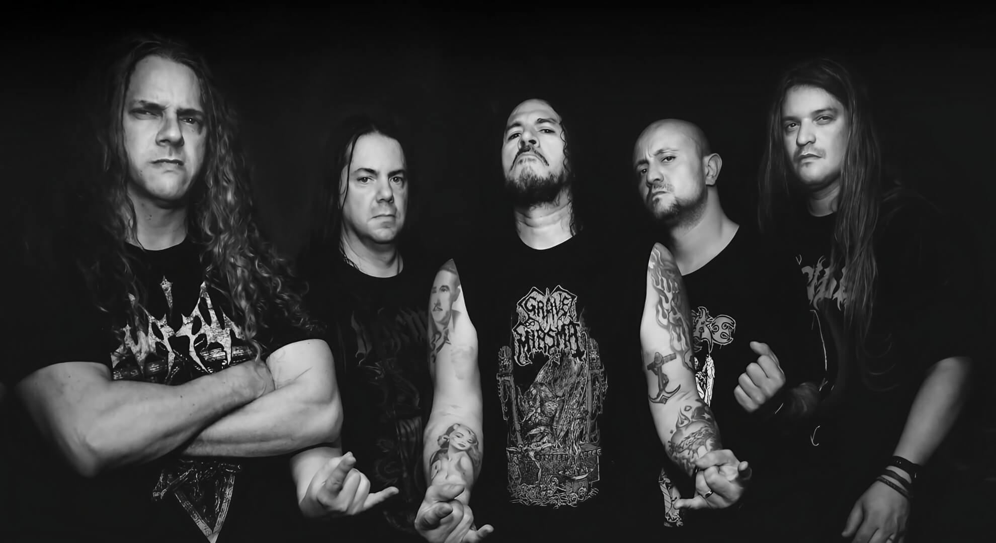 A studio promotional portrait of Masacre. The band members stand in formation, wearing black clothing and projecting a serious, confrontational demeanor.