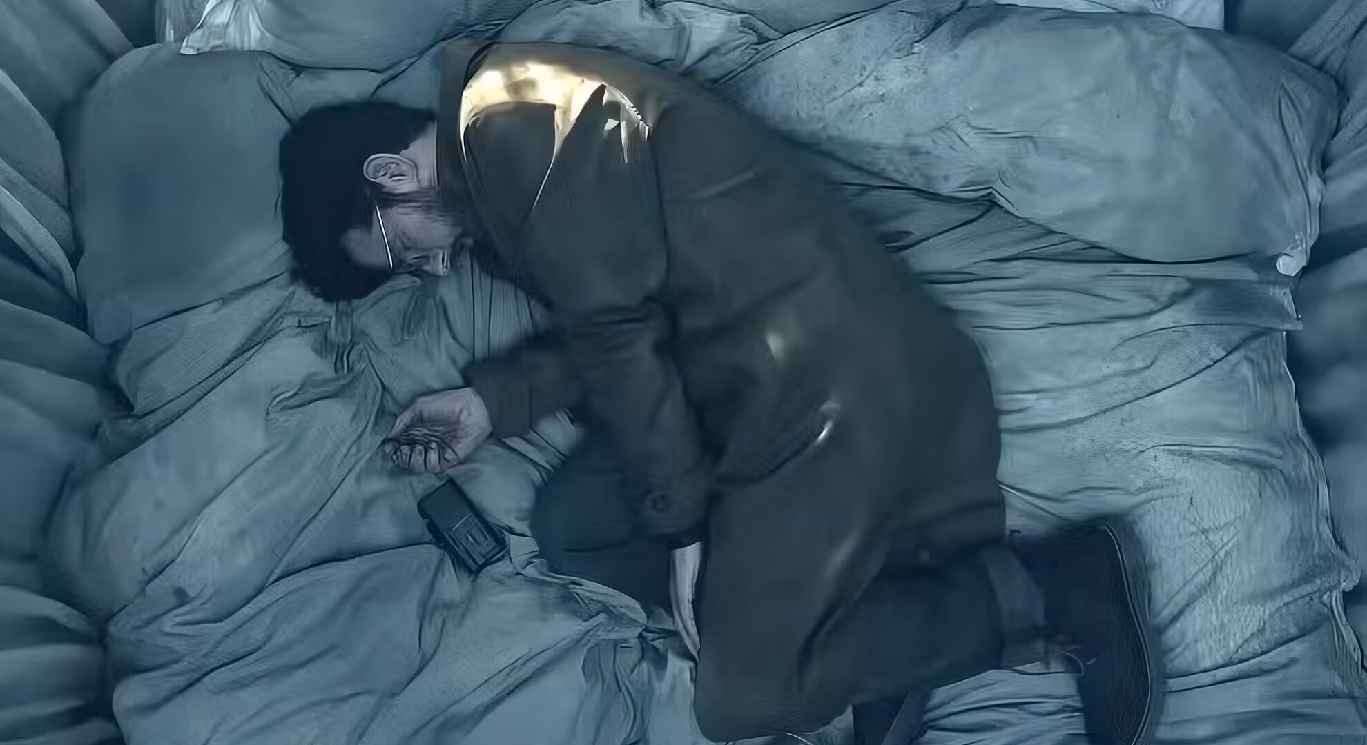 &lsquo;Hokum&rsquo; (2026) film still: Ohm Bauman on a hotel bed, overhead shot, a dark figure pressed against him.