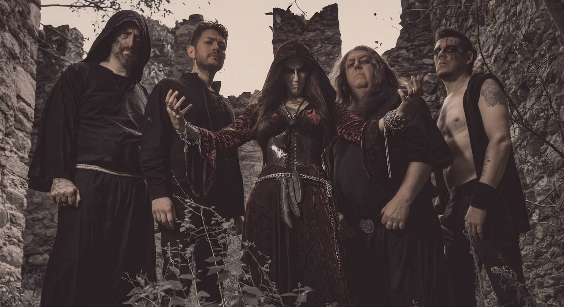 Opera IX Sharpens Its Ancient Poison on ‘Veneficium’ Opera IX five-piece lineup — Dipsas Dianaria centered in red velvet, four members in black robes, stone ruins backdrop.