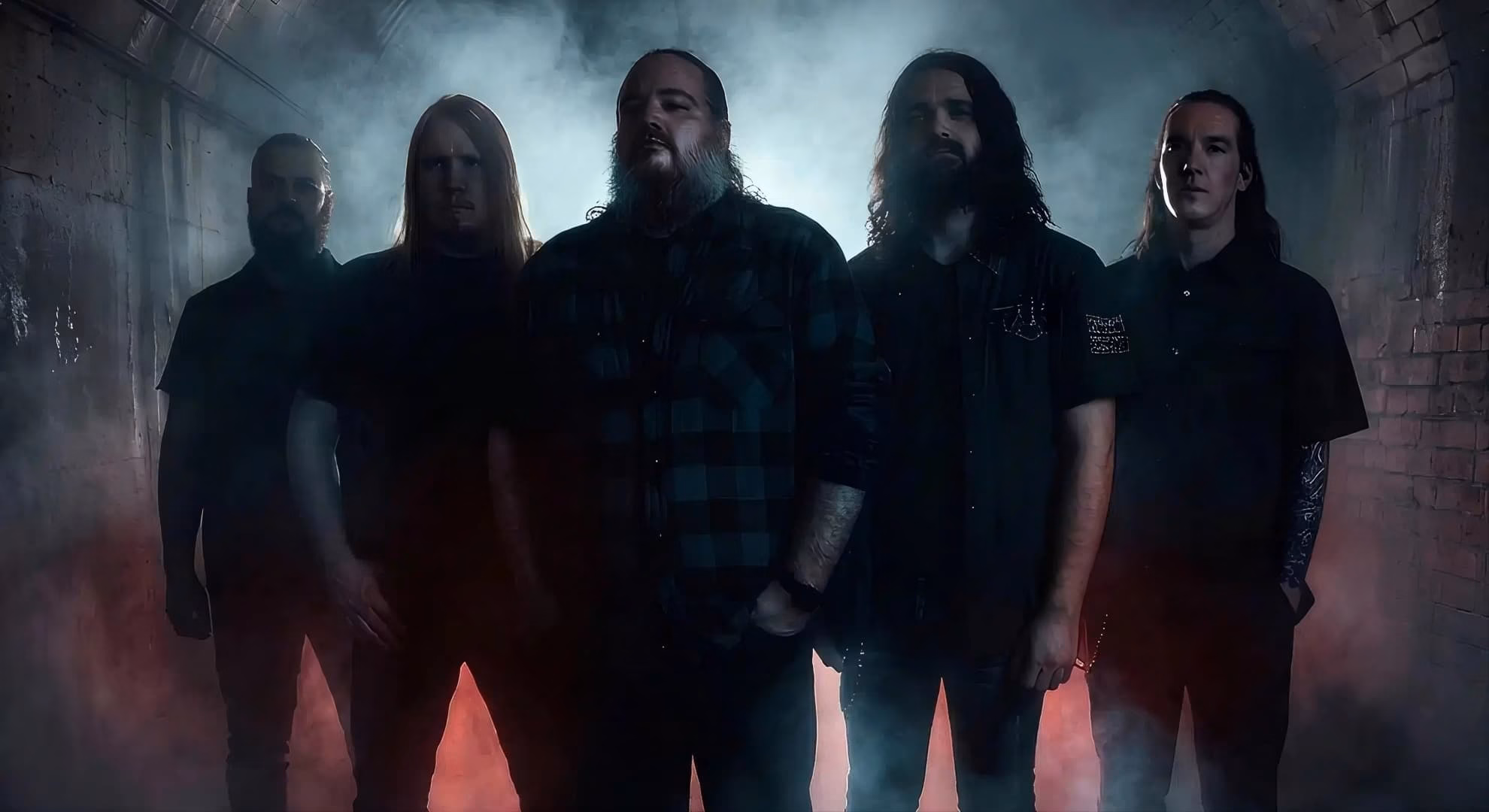 Caelestia Reckon With the Dead on ‘Revelations In Black’ The five members of Caelestia standing in a smoke-filled brick tunnel lit red from below.
