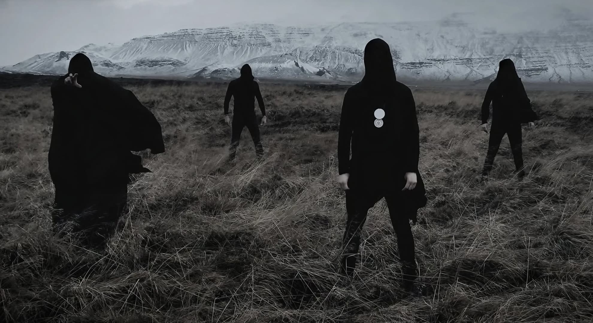 Inferno Descend Into Despair on ‘The Anthropic Sophisms’ Four hooded Inferno members in black robes on a frost-dry grassland plain beneath a snow-covered mesa.
