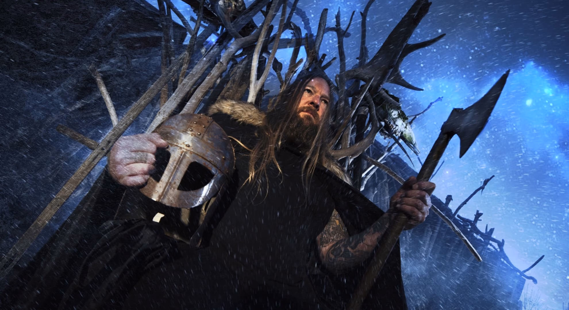 Vidar “Daemon” Jensen of Limbonic Art holds a helmet and axe in a snowy promotional image.