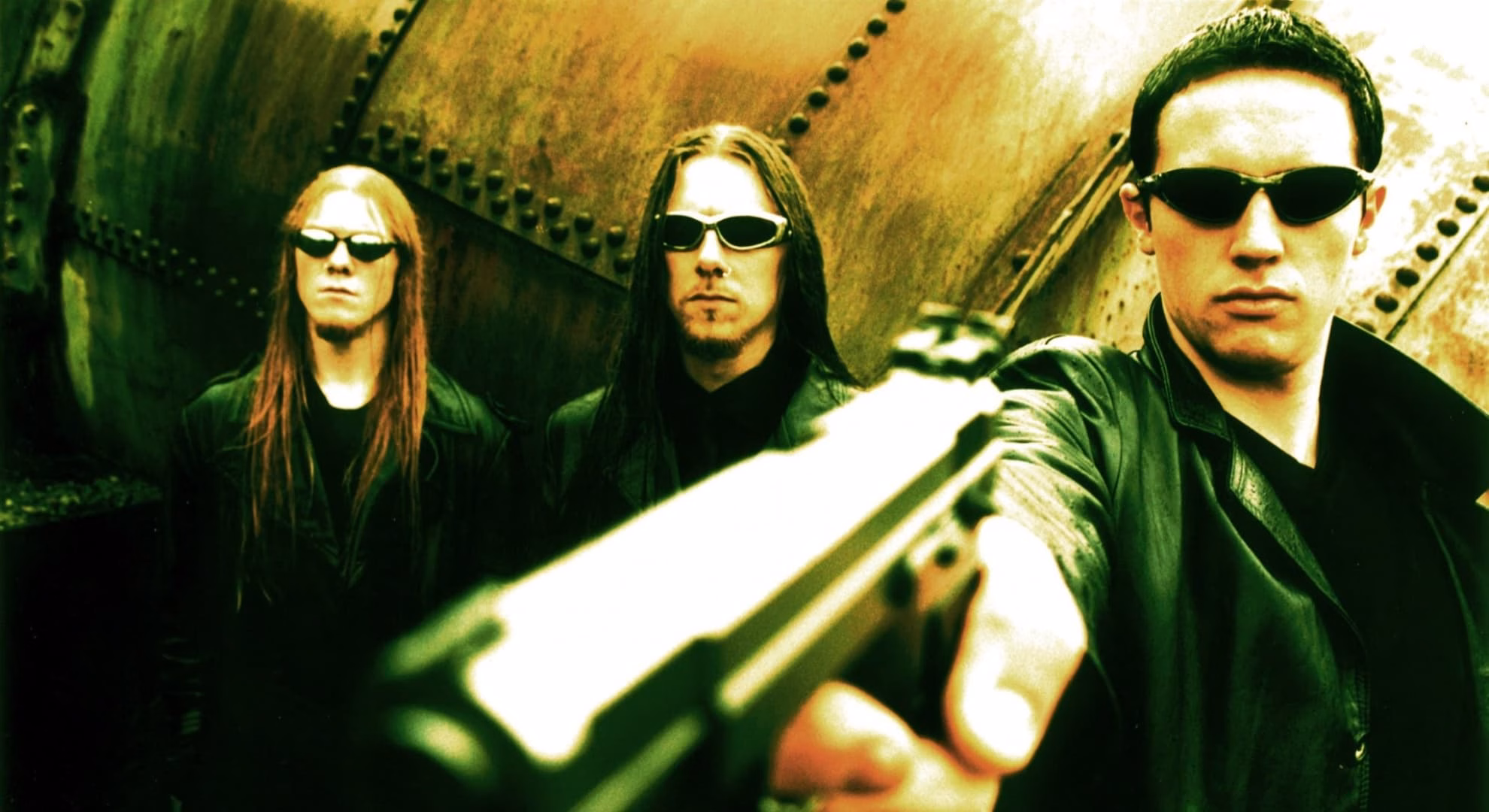 Zyklon and the Machine Inside Norwegian Black Metal Zyklon promotional photo from the ‘World ov Worms’ era, a handgun aimed toward the camera in the foreground.