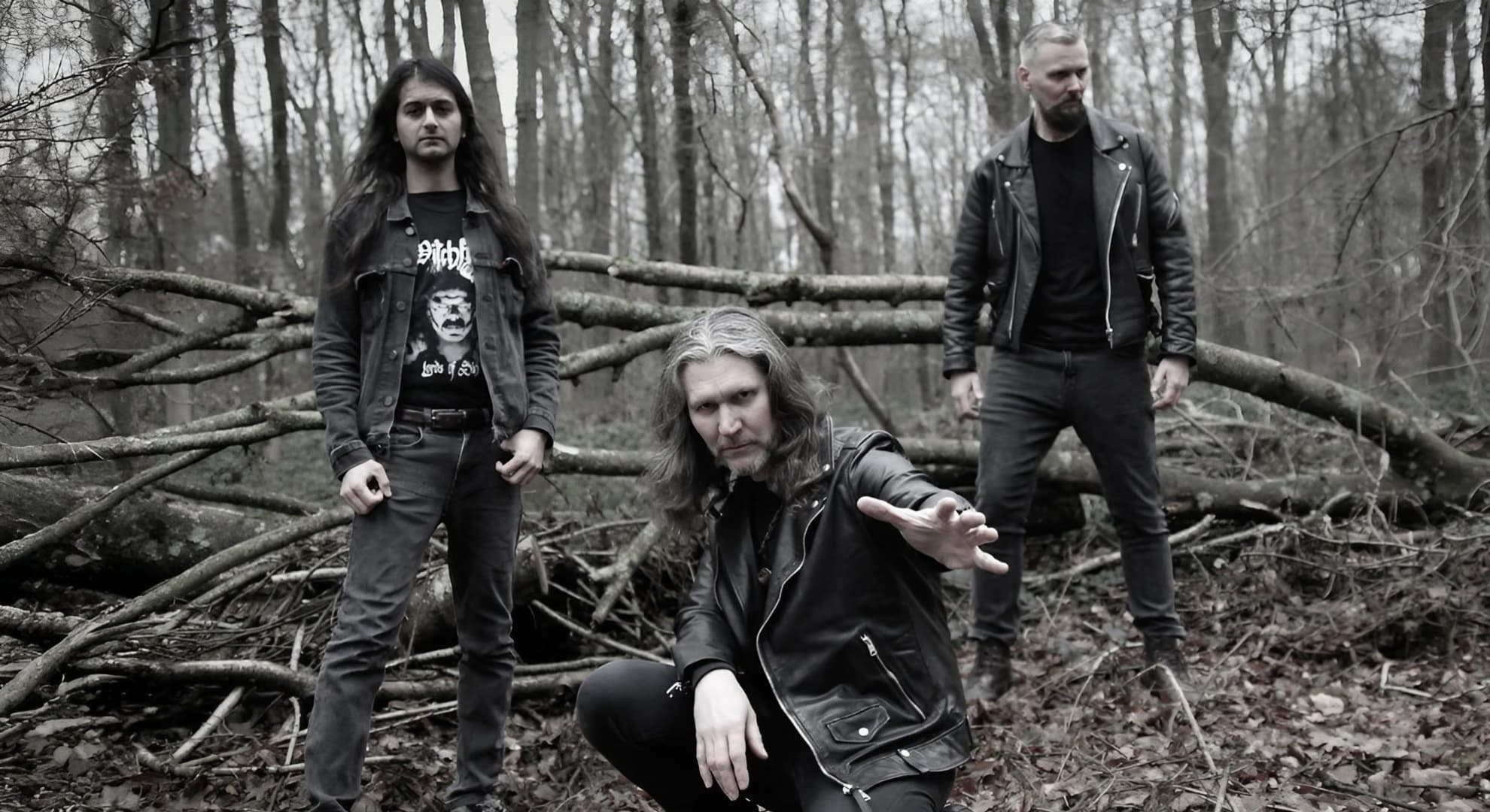 Fen Returns to Roots on ‘Elemental Part One: Mourning Earth’ Fen’s three members stand and crouch among fallen branches in a bare winter wood.