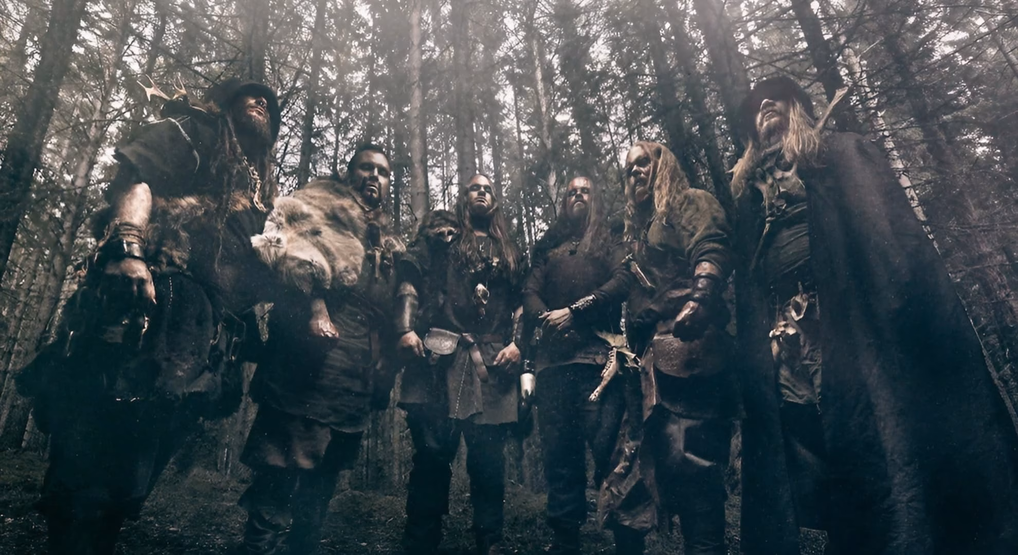 Grimner’s six members in dark battle dress, photographed together in a misty forest.