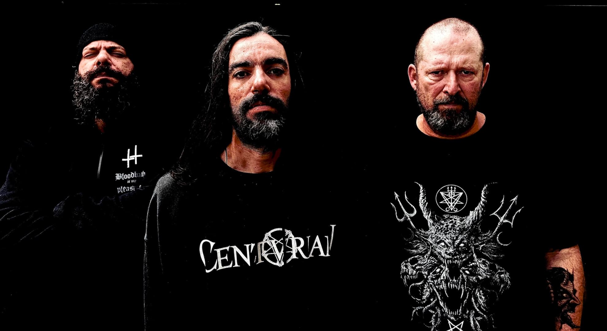 Three members of NervoChaos stand against a black background in band shirts.