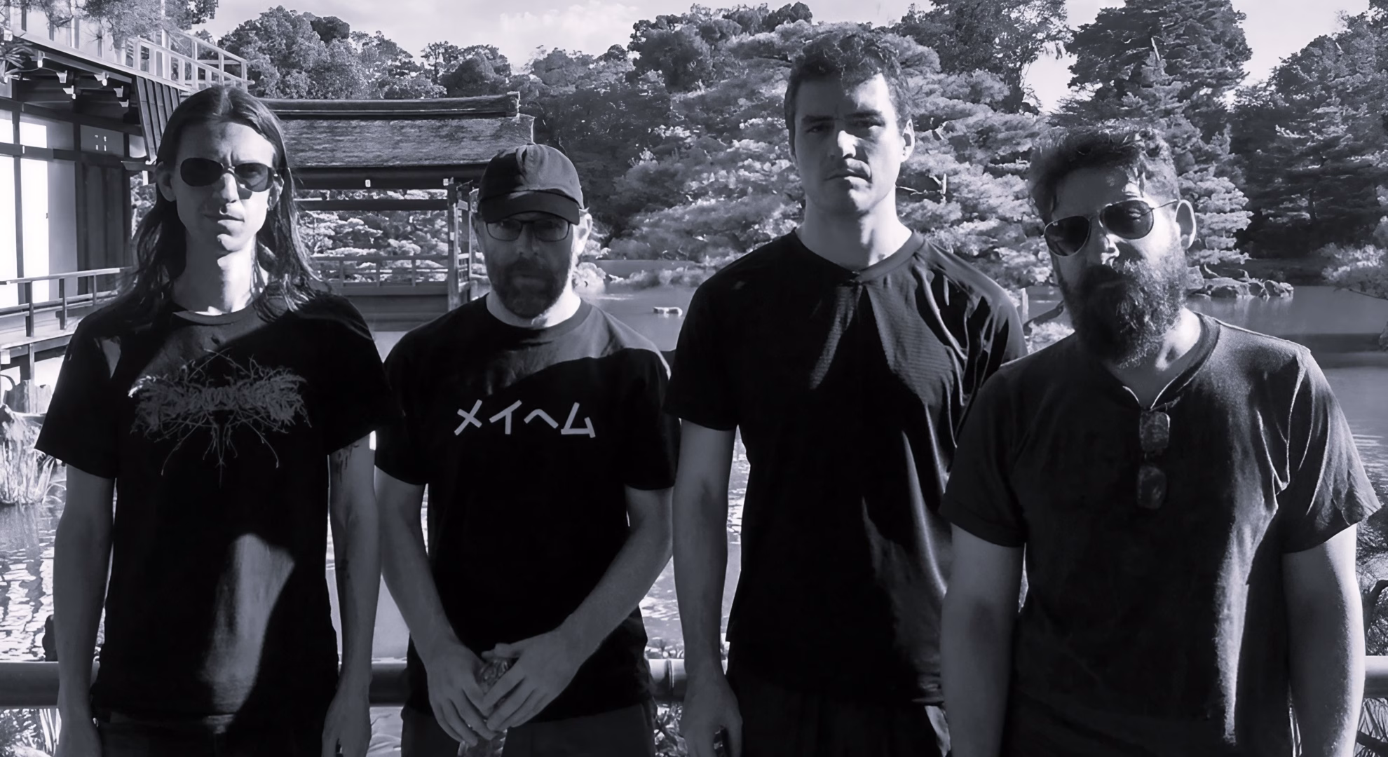 Krallice Return to Ancient Grief on ‘Scour Order’ Krallice’s four members standing together outdoors at a traditional Japanese garden.